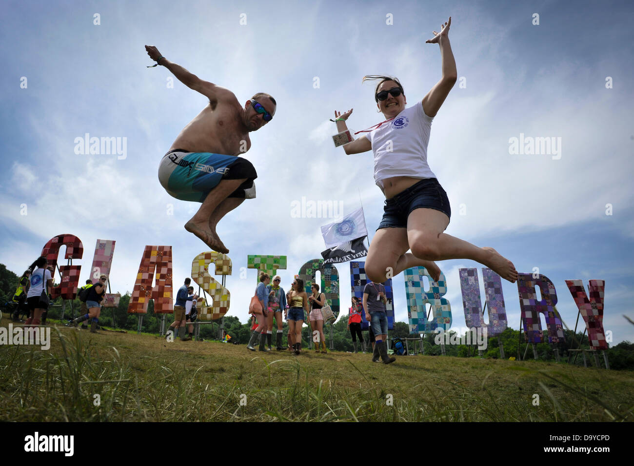 Glastonbury, UK. 28th June 2013. GLASTONBURY MUSIC FESTIVAL Festival goers jumping with excitement in from of large letters that spell out Glastonbury. Its estimated 200,000 people will attend the four day Glastonbury Festival which takes place at Worthy Farm, Pilton Somerset.  June 28. 2013. GLASTONBURY MUSIC FESTIVAL PILTON, SOMERSET, ENGLAND, UK Credit:  Alistair Heap/Alamy Live News Stock Photo