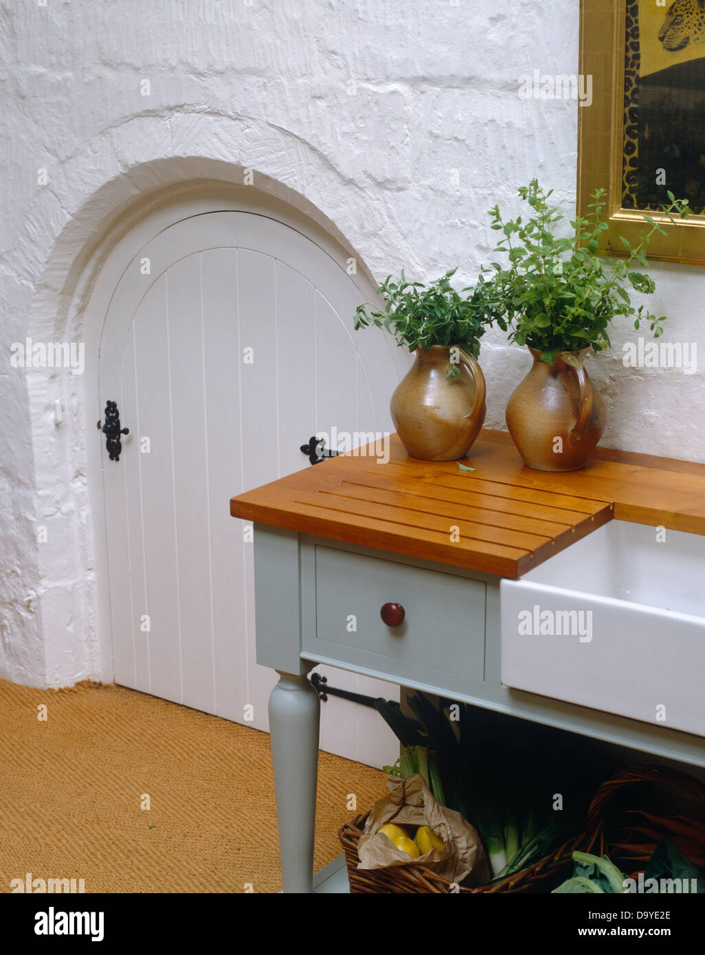 Herbs In Pottery Jugs On Wooden Draining Board On