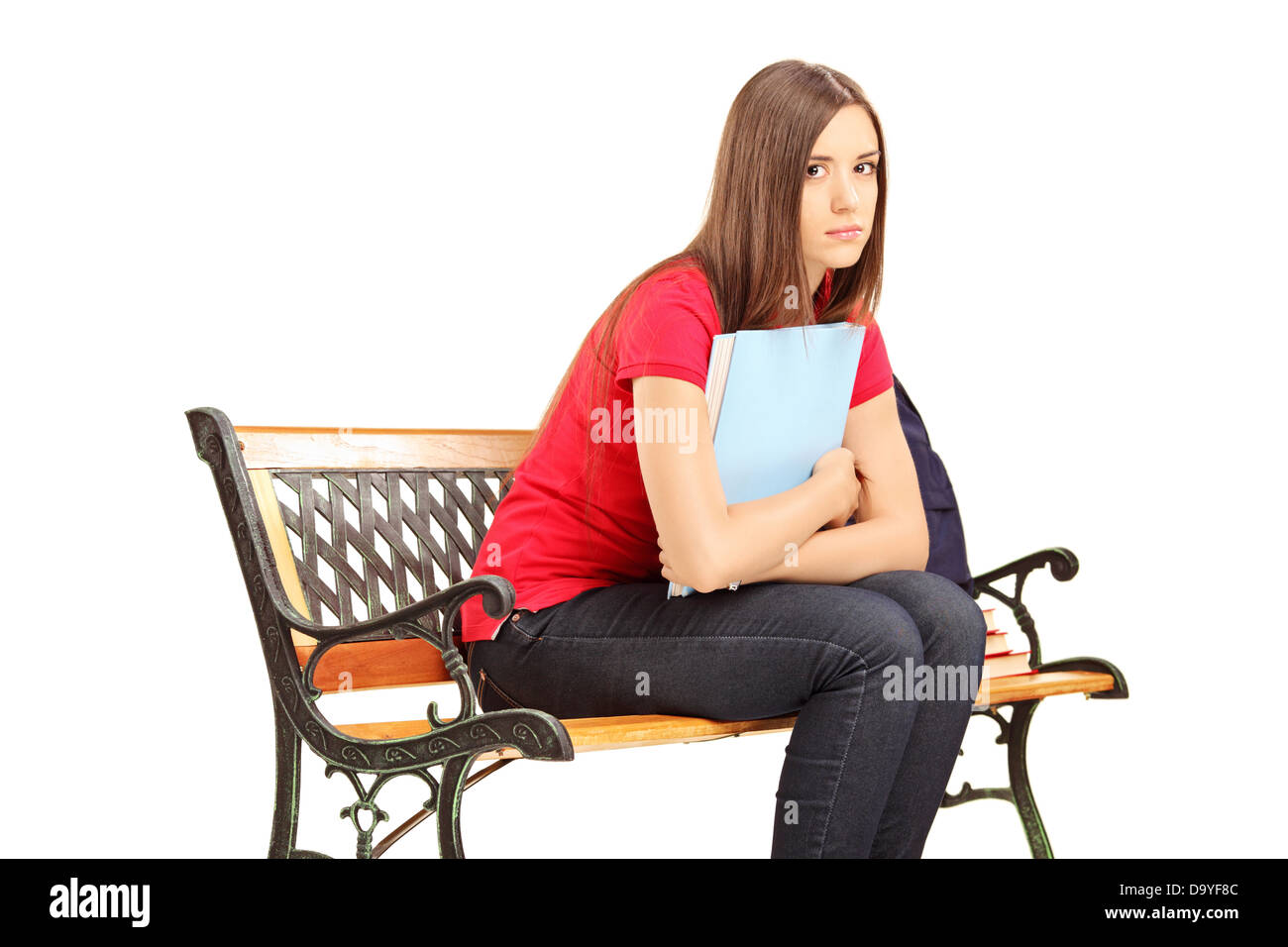 Unhappy female student sitting on a wooden bench with notebook Stock Photo