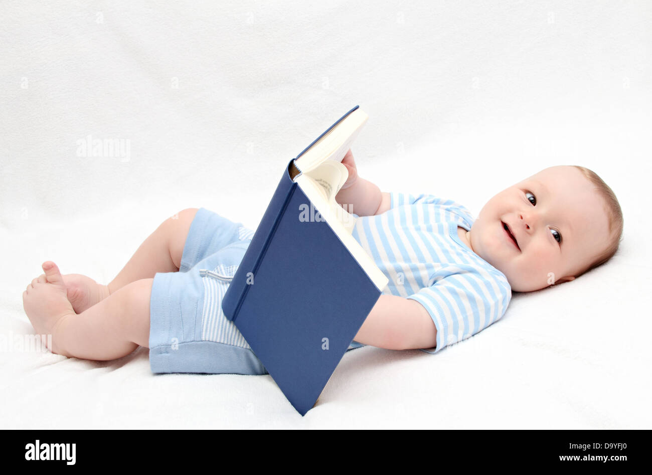 baby reading a book on back Stock Photo