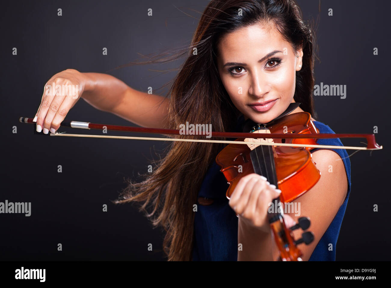 attractive young woman playing violin on black background Stock Photo