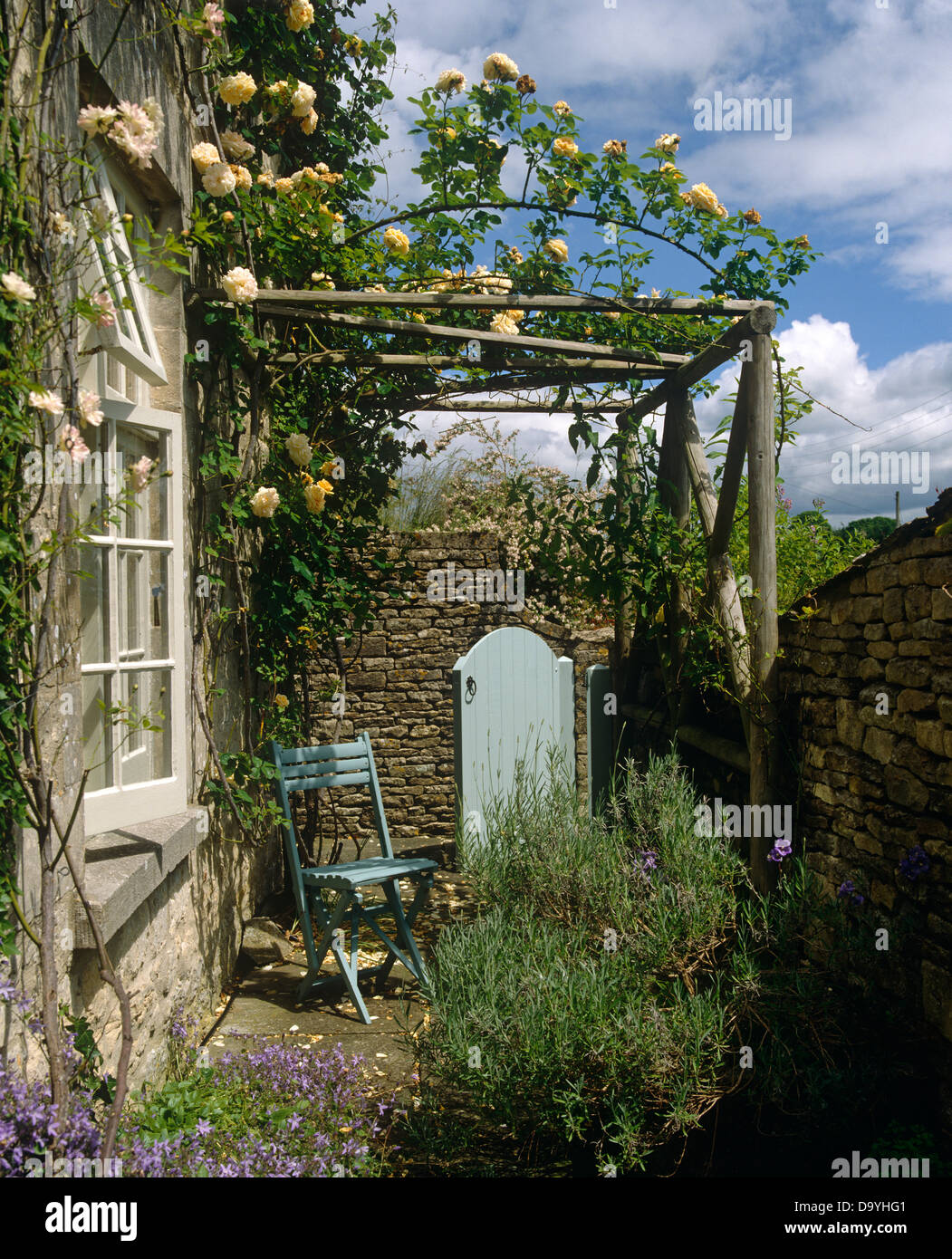 Pale Blue Chair And Wooden Door In Stone Wall On Cottage Patio