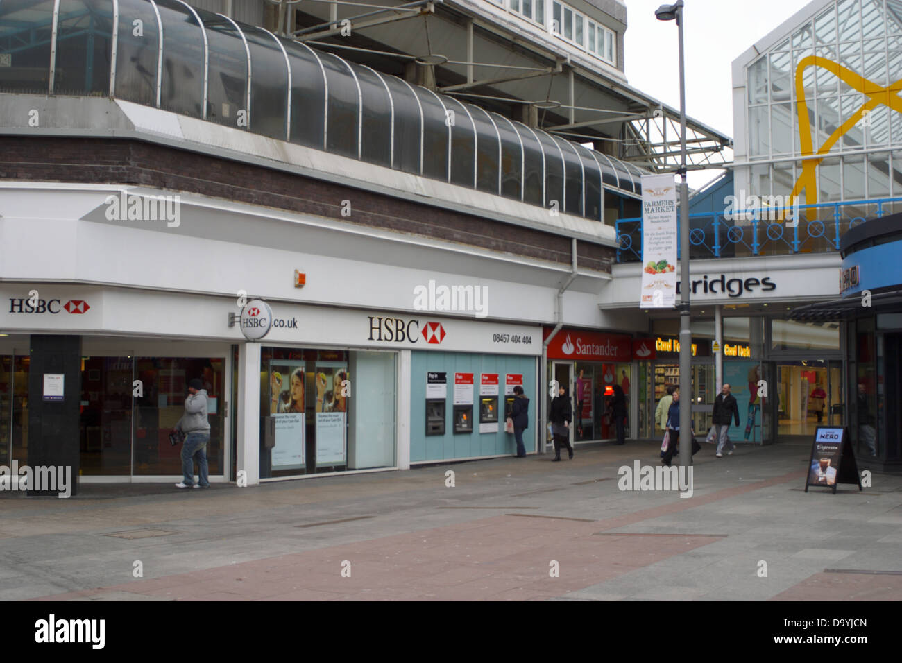 HSBC Bank, cash dispenser use, shoppers entering and leaving the bridges shopping center in Sunderland. Stock Photo