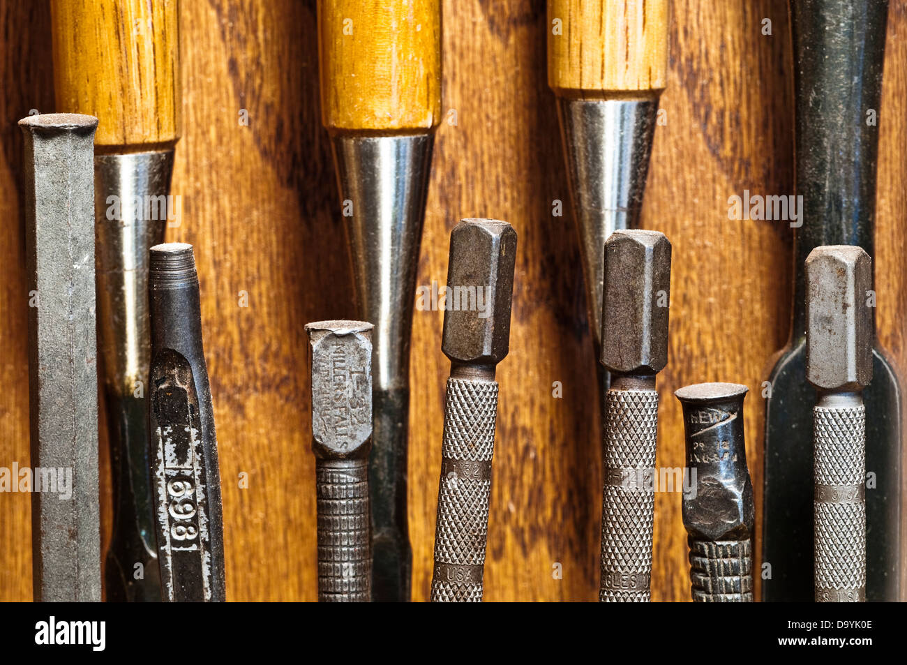 Woodworking hand tools including awls, punches, chisels and sets displayed in a wall cabinet. Stock Photo