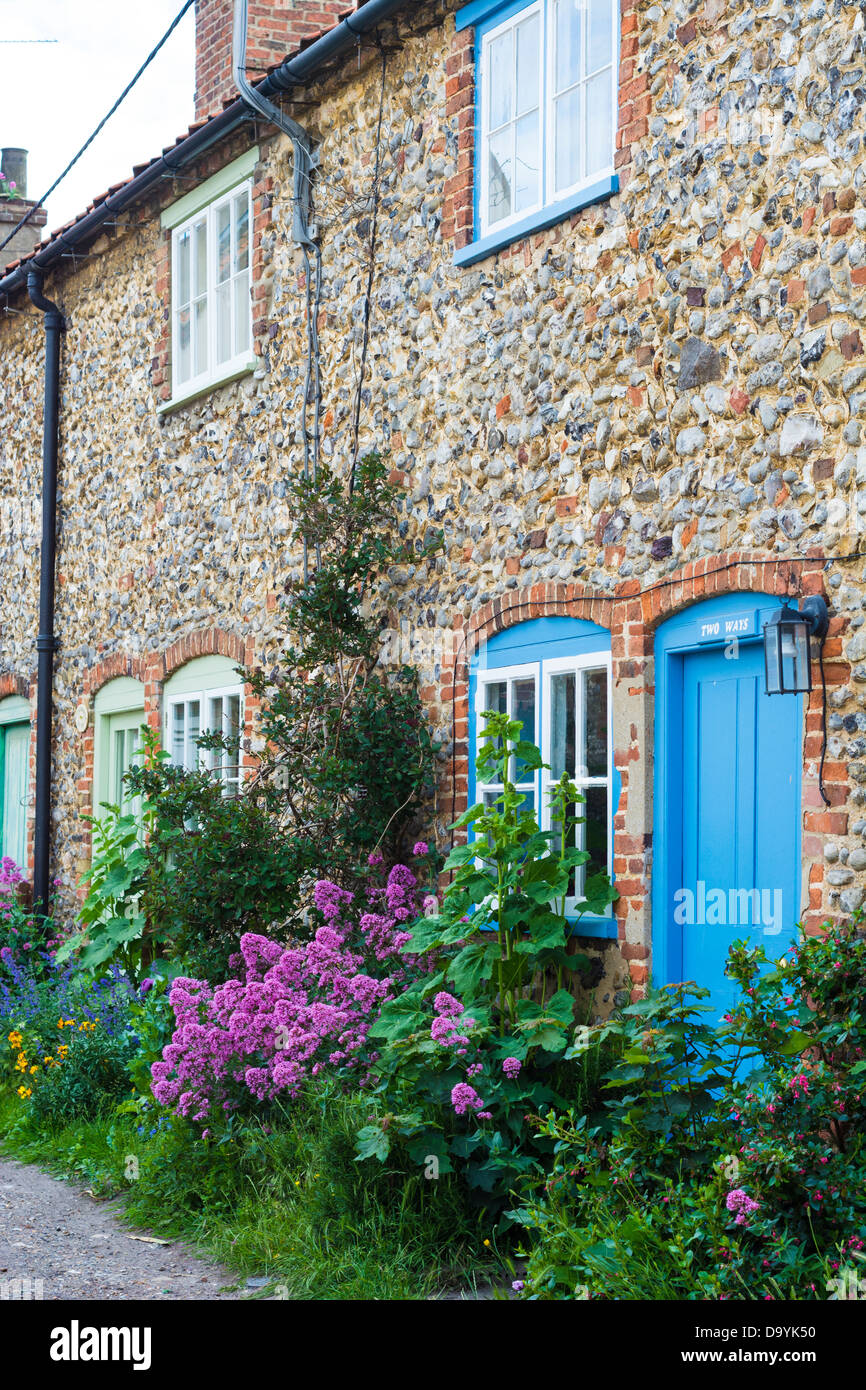 Row of flint faced faced cottages with red valerian Stock Photo