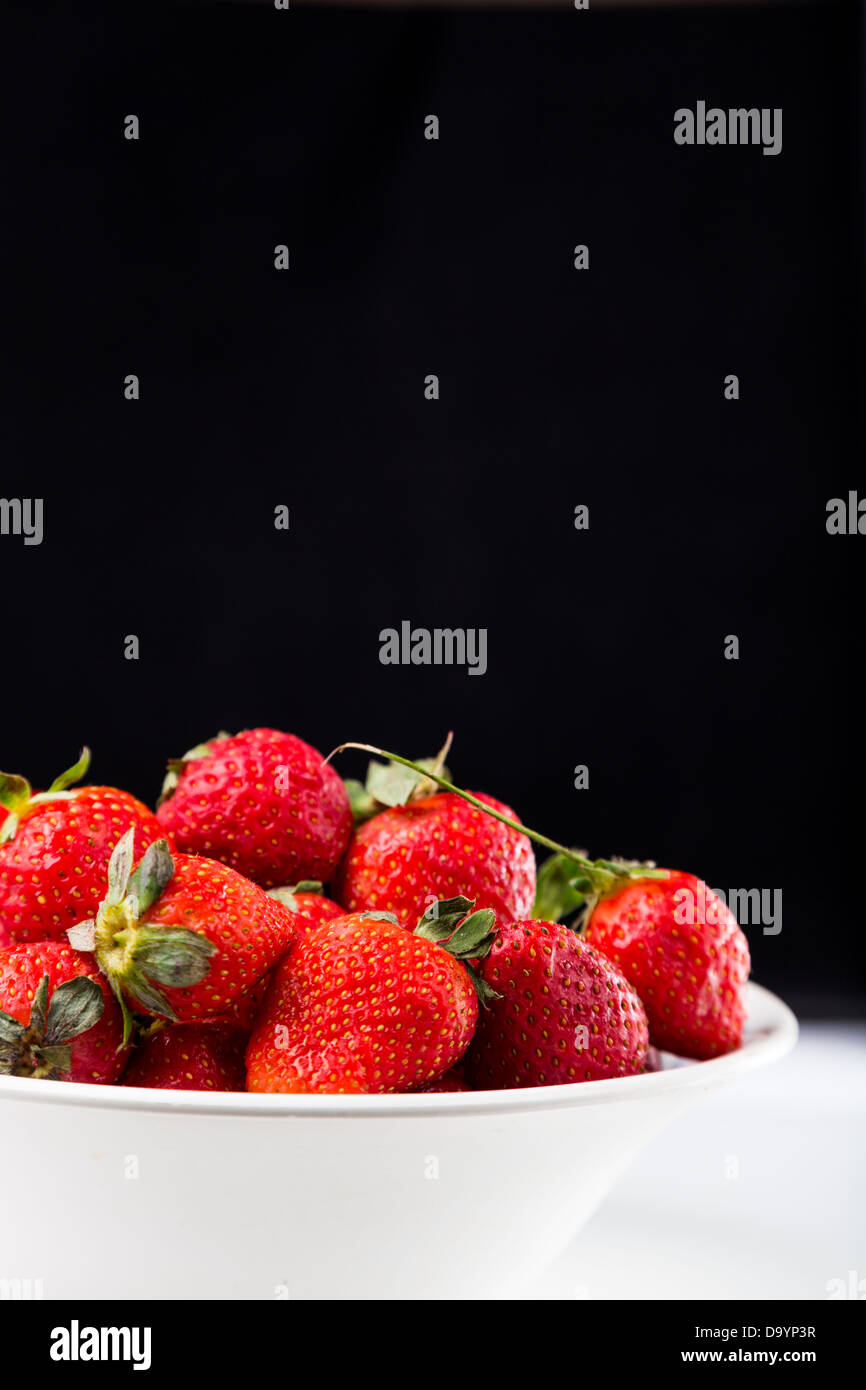 fresh strawberry in white plate on black background Stock Photo - Alamy