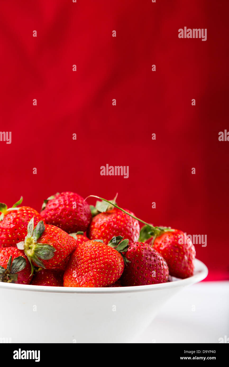 fresh strawberry in white plate on red background Stock Photo - Alamy