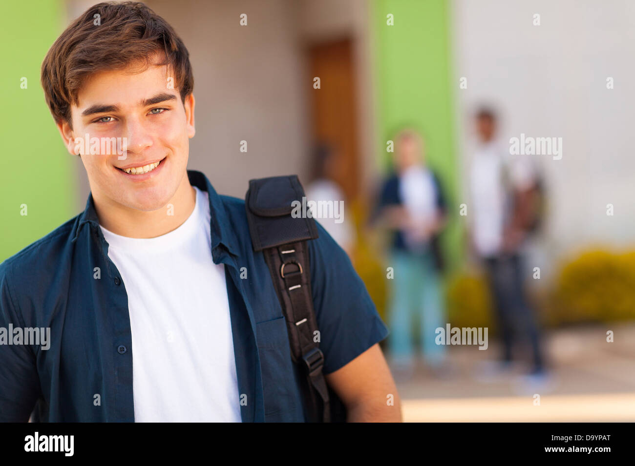 smiling teen boy carrying schoolbag Stock Photo