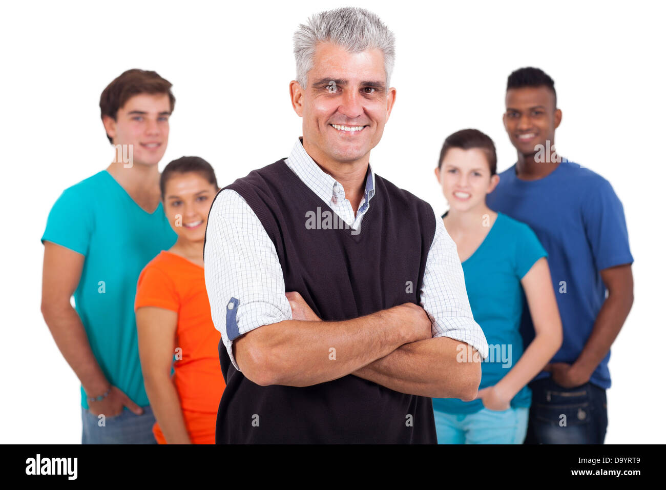 happy middle aged teacher with arms folded in front of high school students isolated on white background Stock Photo