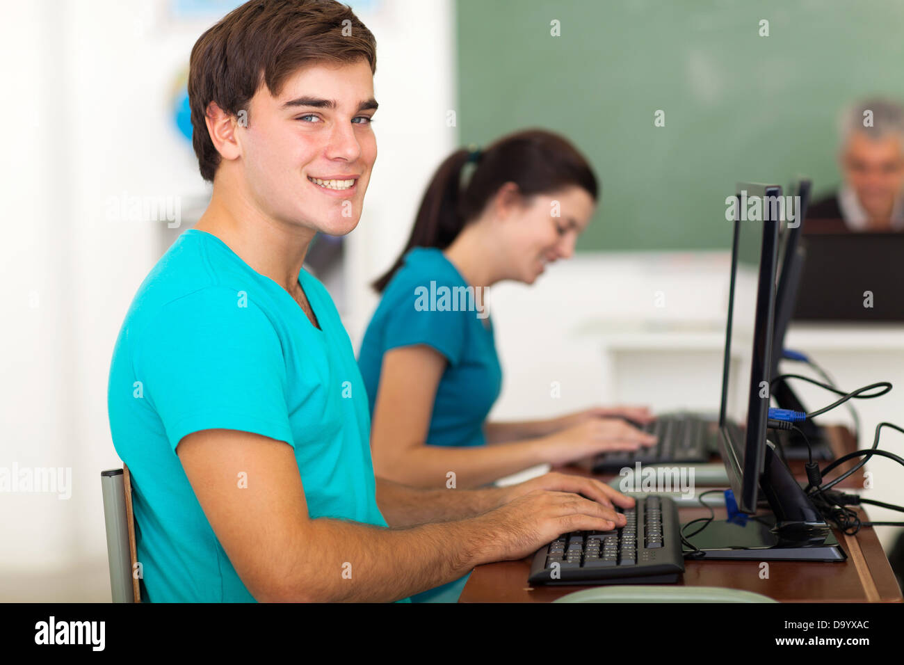 happy college student with classmate using the computer in classroom