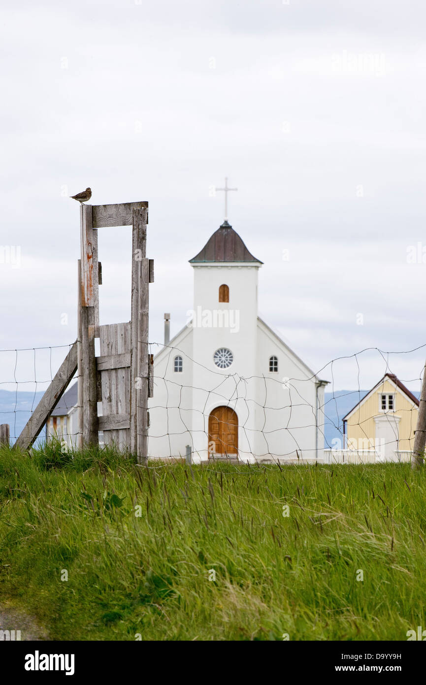 Church built in 1926 with whimbrel (Numenius phaeopus) resting on the gate Flatey Island Breiðafjörður Iceland Stock Photo