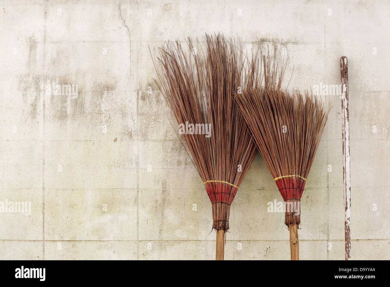 brooms on white wall Stock Photo