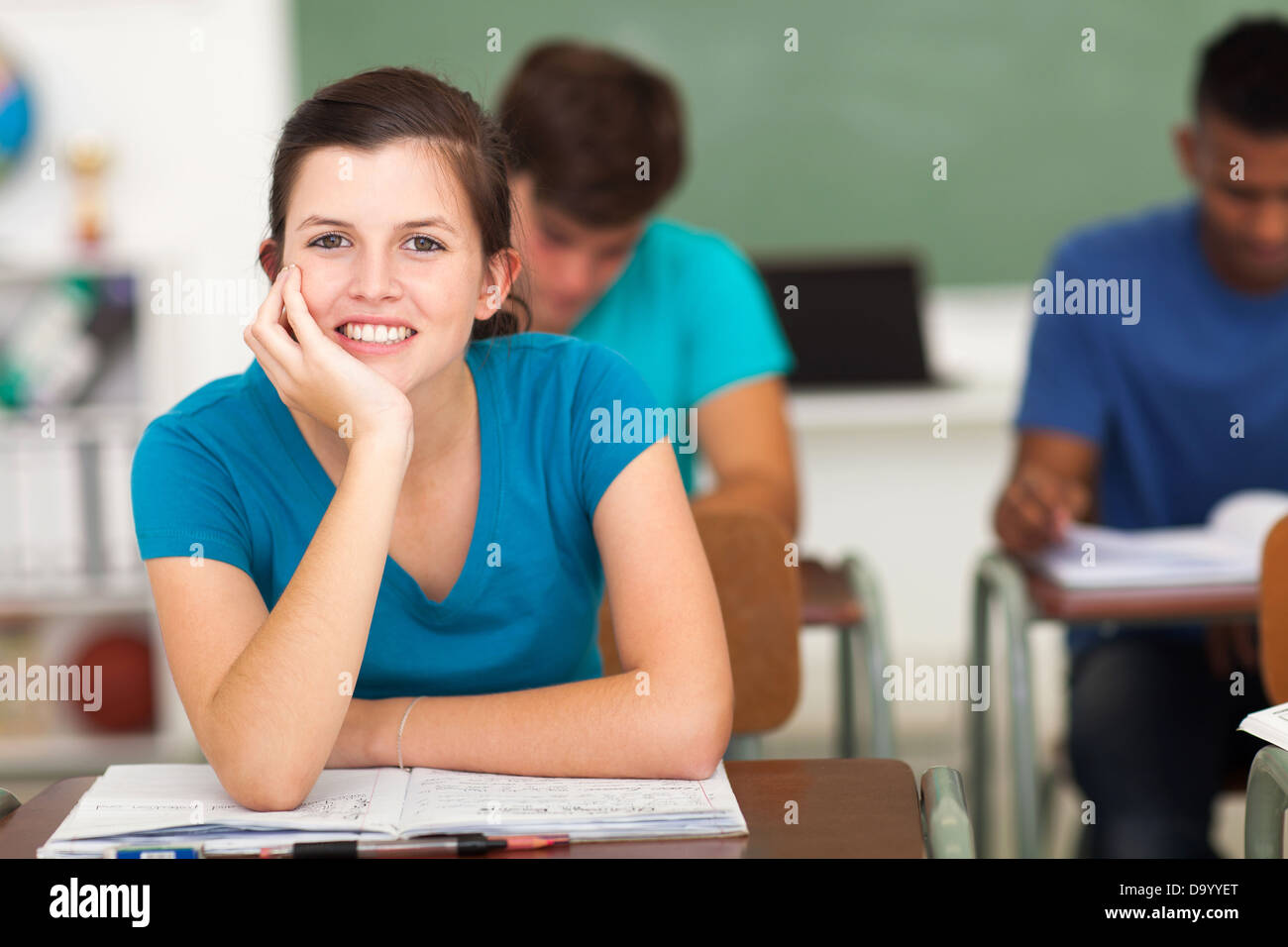 close up portrait of teenage high school girl sitting in classroom with classmates Stock Photo
