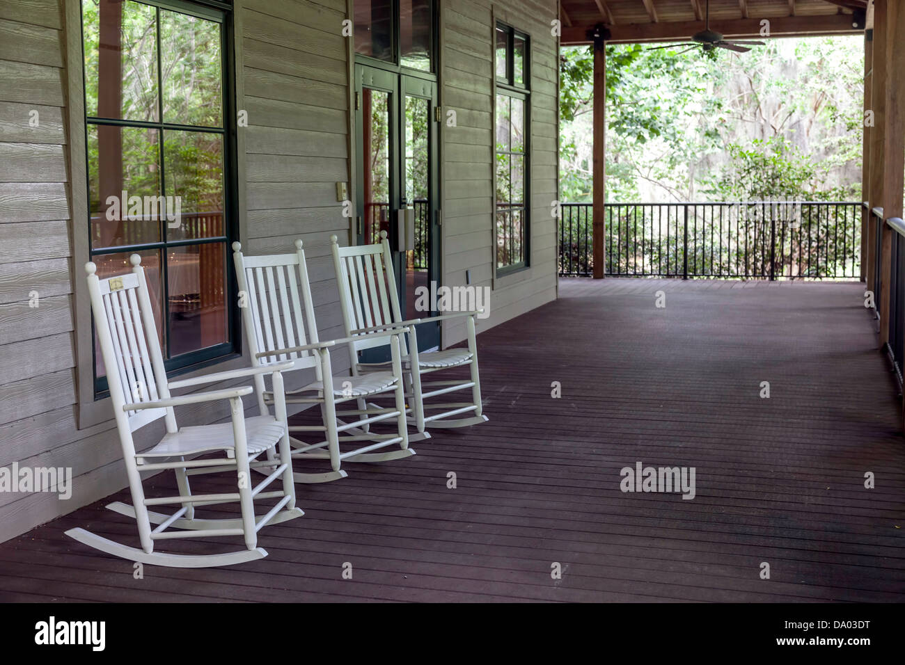 Three white rocking chairs on the veranda of the Kanapaha Gardens ...