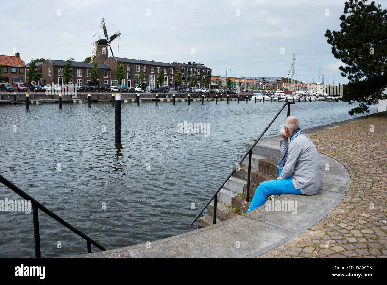 man sitting on the stairs to the water and thinking Stock Photo