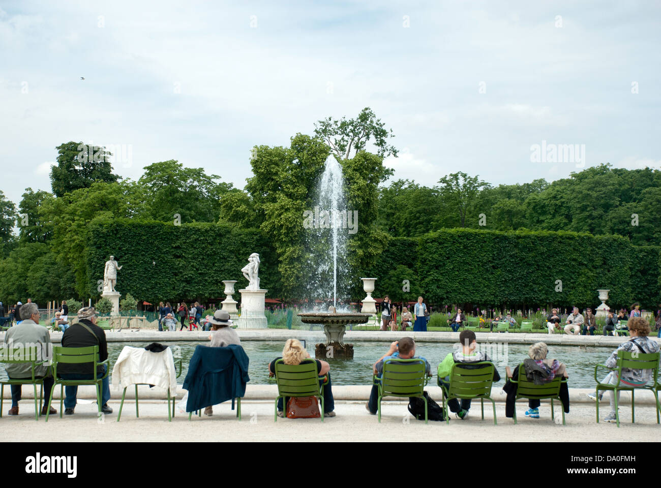People relaxing in chairs beside a fountain in the Jardin des Tuileries, Paris. Stock Photo