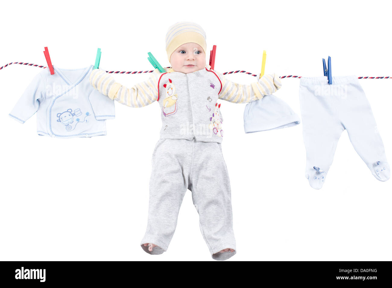Little baby boy hanging on a clothesline, drying on clothespins on rope ...