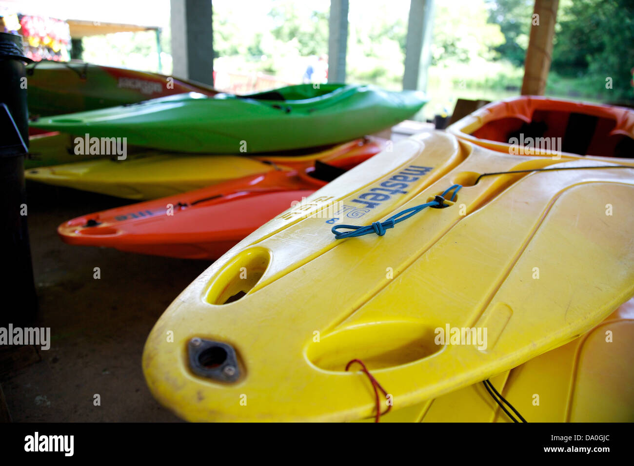 Stack of coloured kayaks waiting to be used at a boat hire business