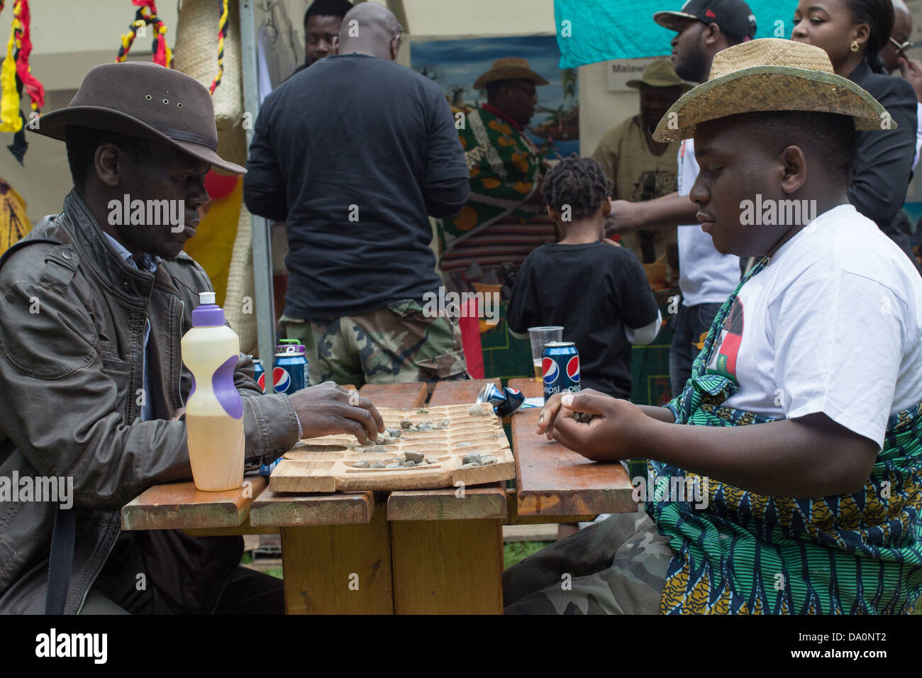 Two men play a traditional African board game. Stock Photo