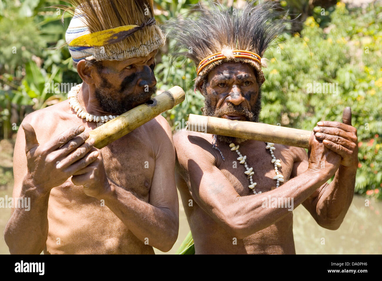 Simbu clansmen play hand-made flutes for visitors, Warabena village, Asaro District, near Goroka, Papua New Guinea Stock Photo