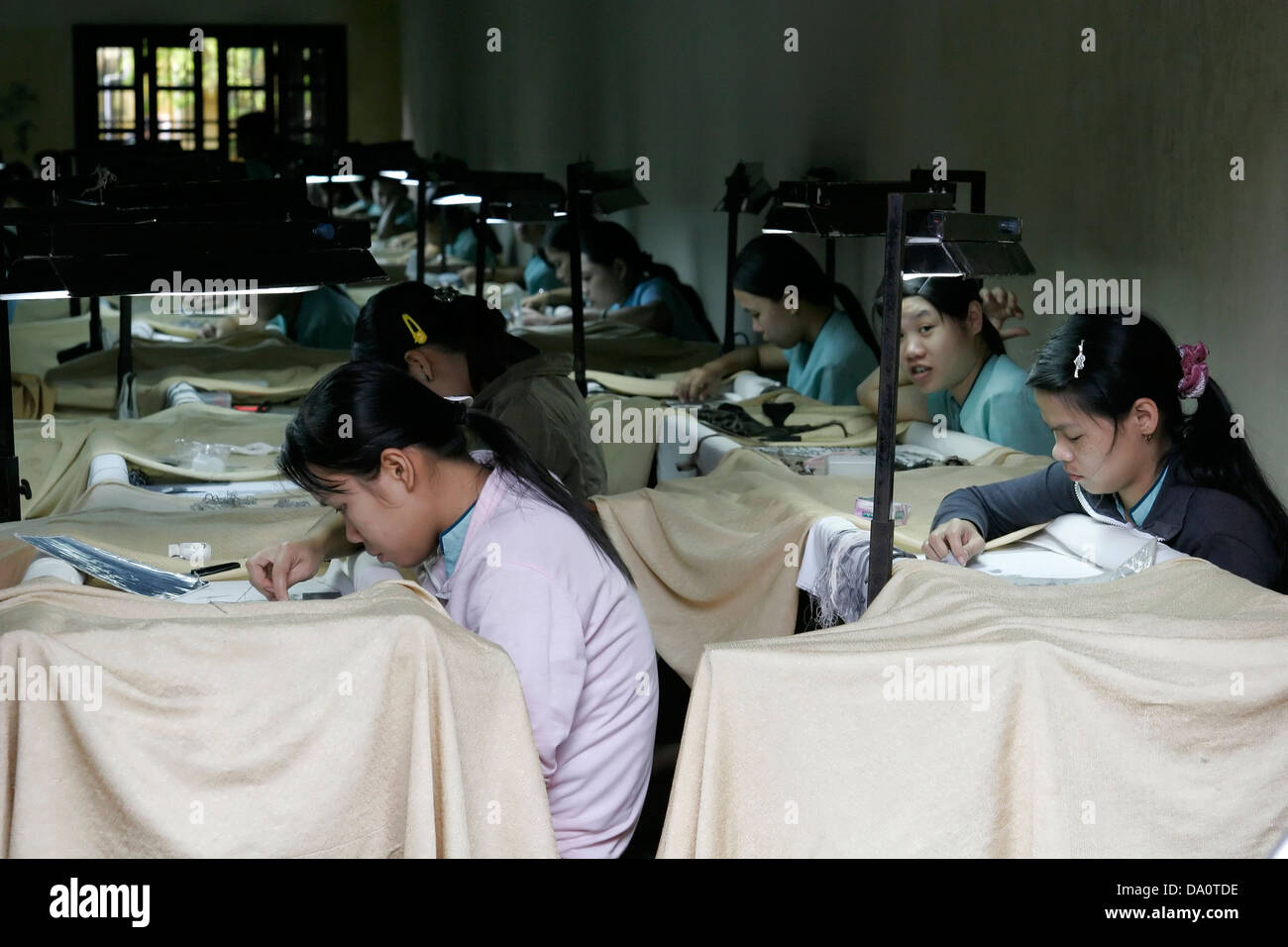 young women working at sewing factory making tedious handmade items, Hanoi, Vietnam Stock Photo