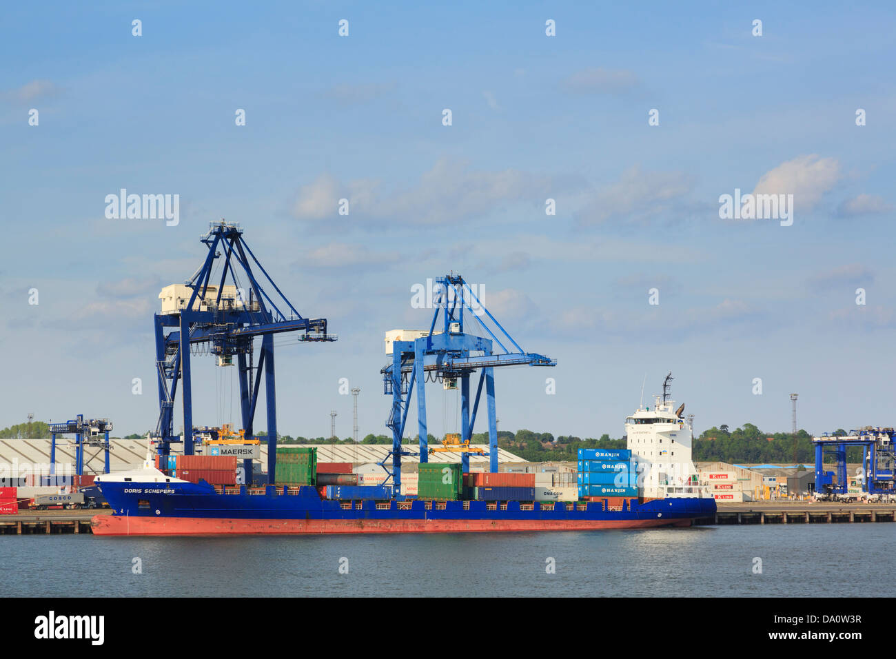 Gantry crane lifting containers on to a container ship for global trade docked in terminal in Port of Felixstowe, Suffolk, England, UK, Britain Stock Photo