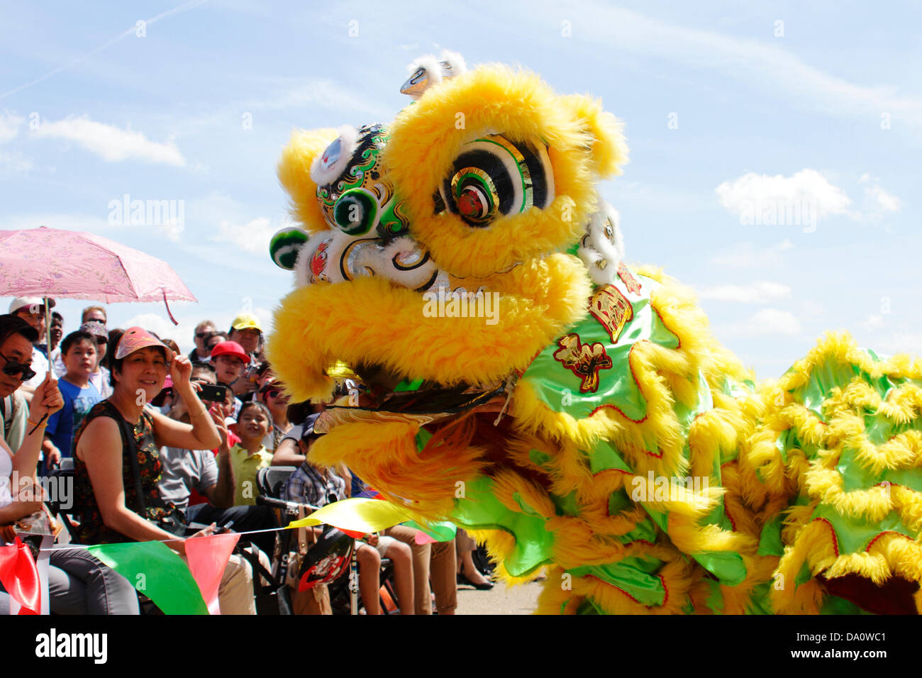 Spectators at the Hong Kong Cultural Festival, part of the London Hong Kong Dragon boat festival are entertained by a traditional Chinese Dragon dance performed by the Medway Dragon and Lion Dance group. London UK Stock Photo