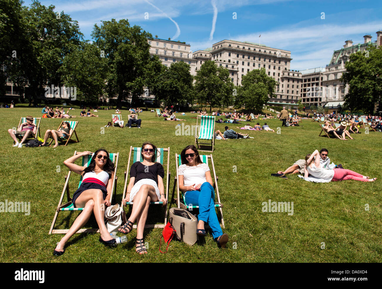 People sunbathing in Green Park London UK on Sunday 30th June Summer 2013 Stock Photo