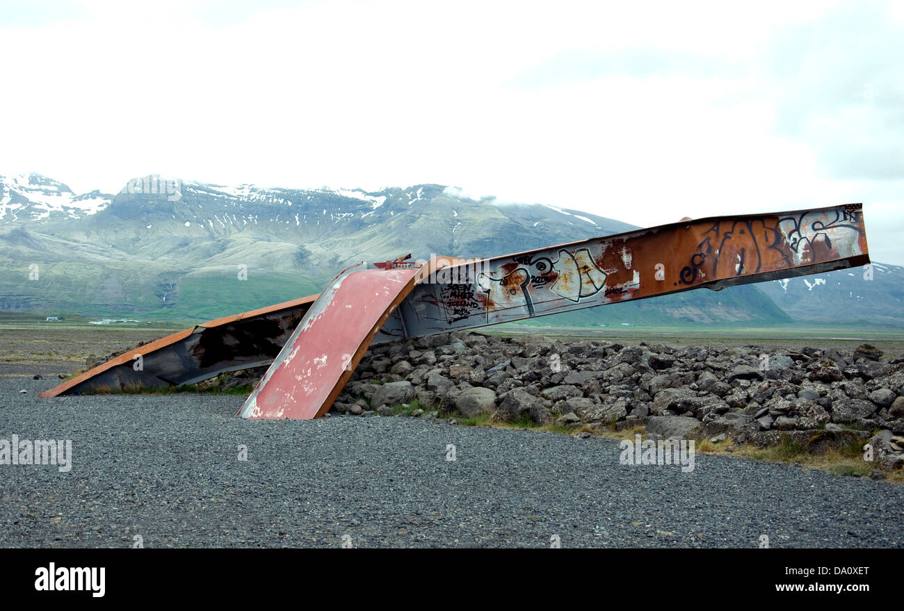 On Iceland's south coast the twisted strut of an iron bridge destroyed by raging floodwaters remains as informal memorial Stock Photo