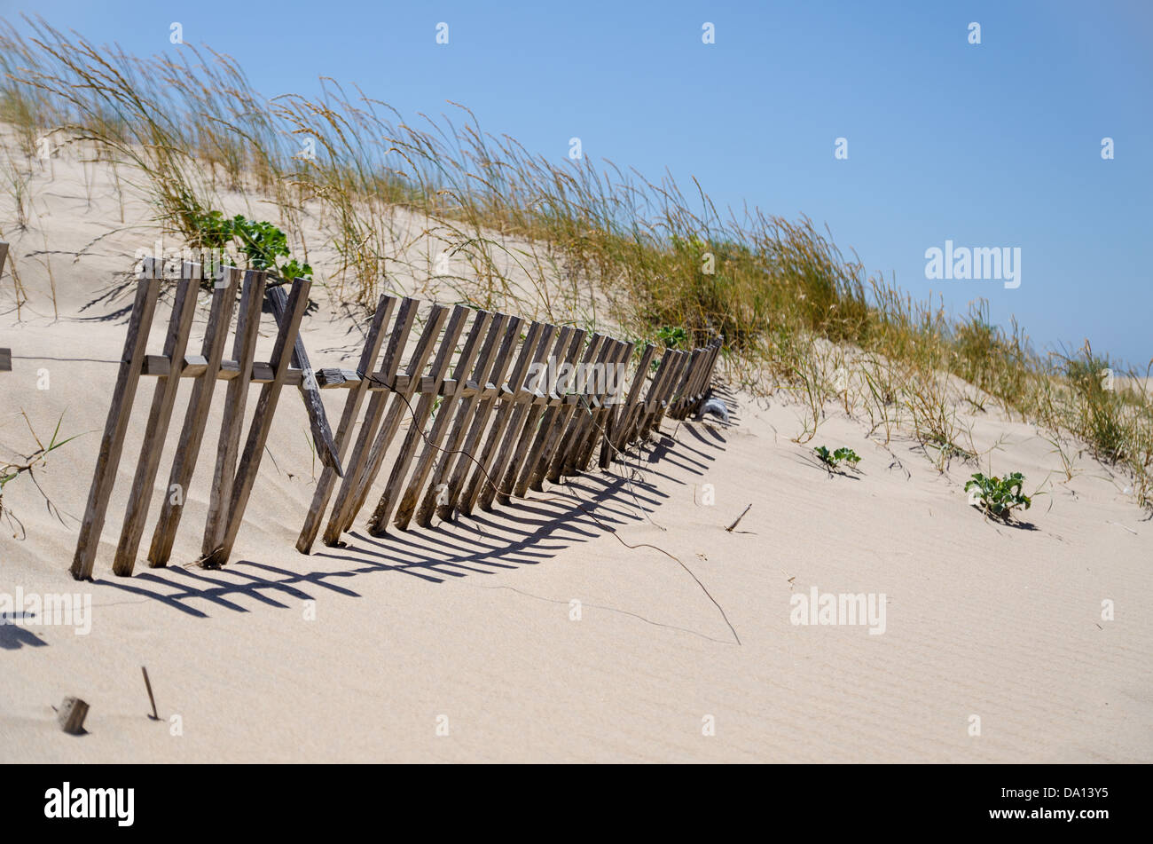 Sand dunes with buried fence Stock Photo