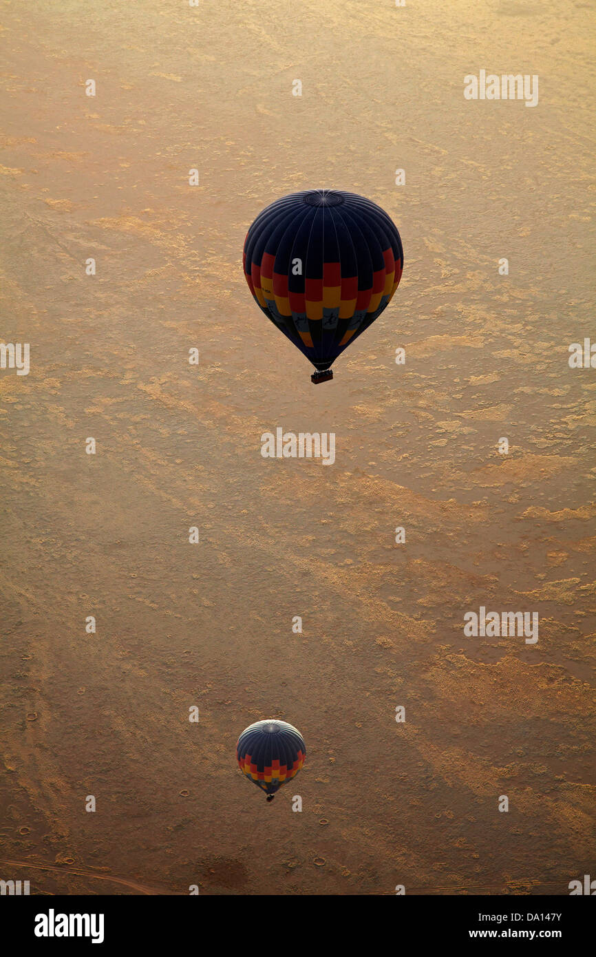 Hot air balloons and early light over Namib Desert, near Sesriem, Namibia, Africa - aerial Stock Photo