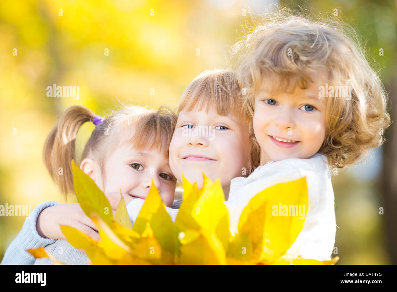 Happy children with maple leaves in autumn park Stock Photo - Alamy