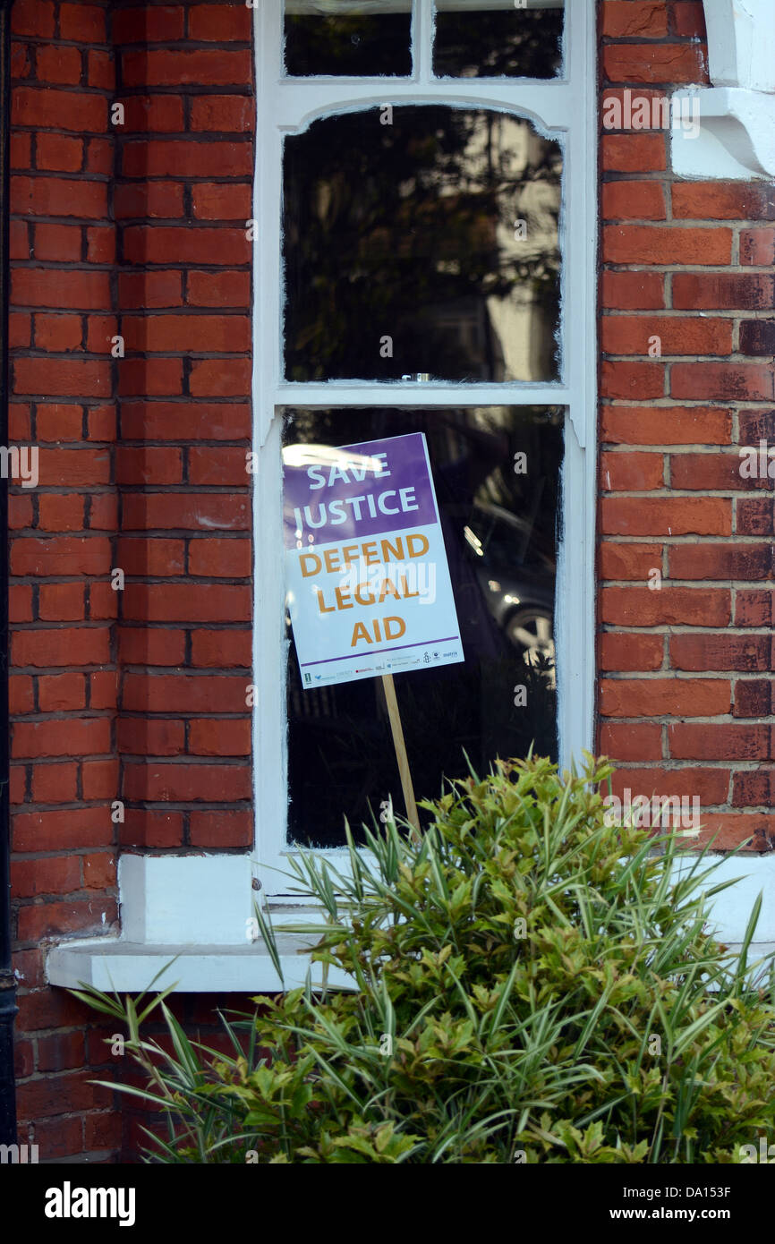 A placard in a house window save justice defend legal aid Stock Photo