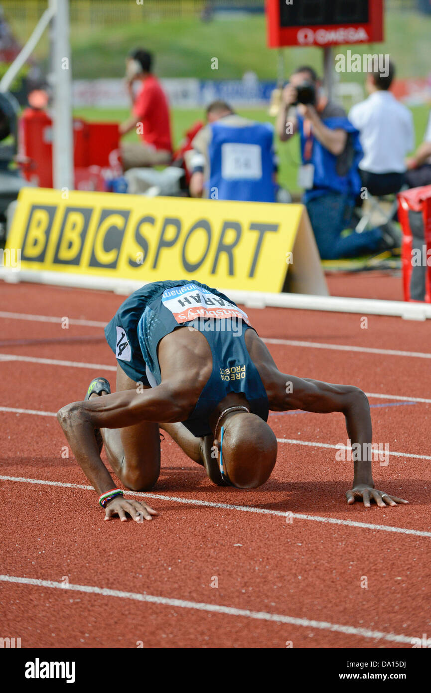 Birmingham, UK. 30th June 2013. Mo Farah of Great Britain kisses the ground after winning the men's 5000m event at the 2013 Sainsbury's Birmingham Grand Prix IAAF Diamond League meeting. The Olympic champion's time of 13:14.24 was enough to beat Yenew Alamirew and Hagos Gebrhiwet, both of Ethiopia. Credit:  Russell Hart/Alamy Live News. Stock Photo