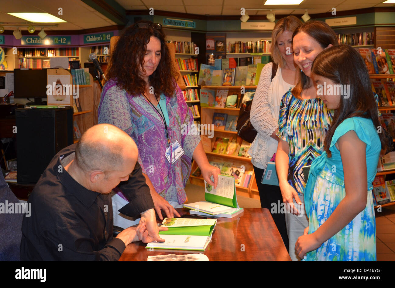 Jim Ottaviani thumbprints a book at book signing for his new book ...