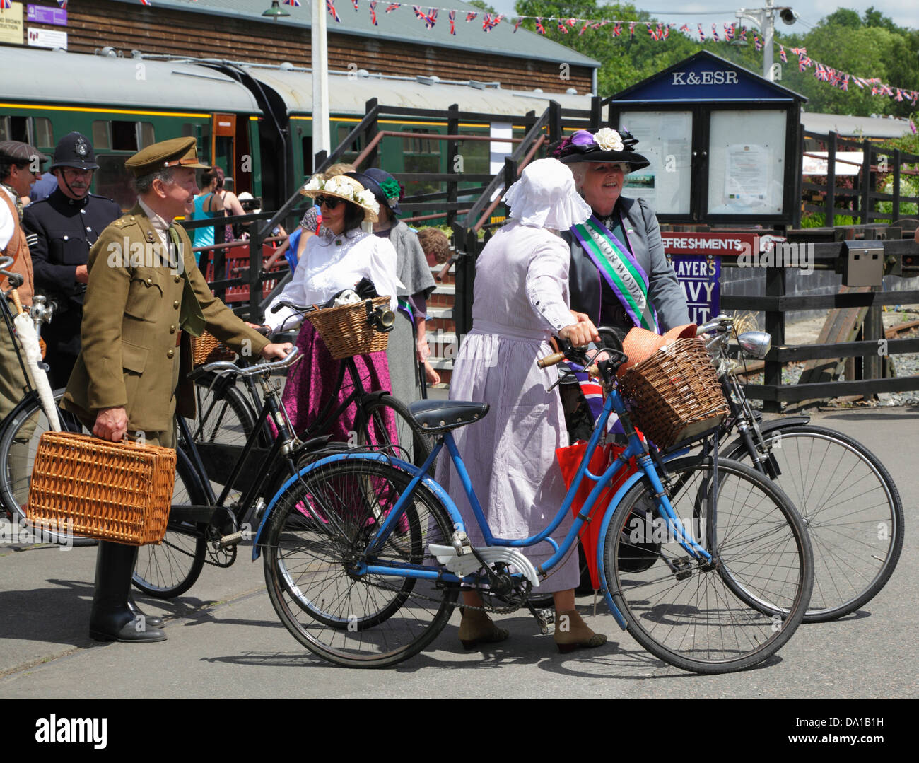 People in period costume with vintage bicycles arriving at Tenterden station for re-enactment of life in WW1, Kent, UK, GB Stock Photo