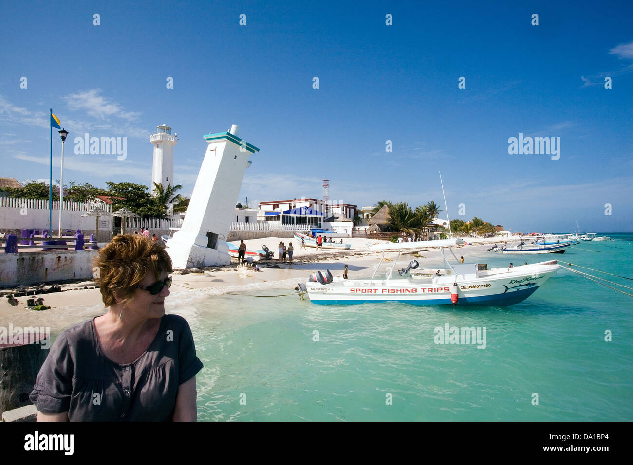 Woman holiday maker relaxes by old lighthouse Puerto Morelos, Quintana Roo, Mexico Stock Photo