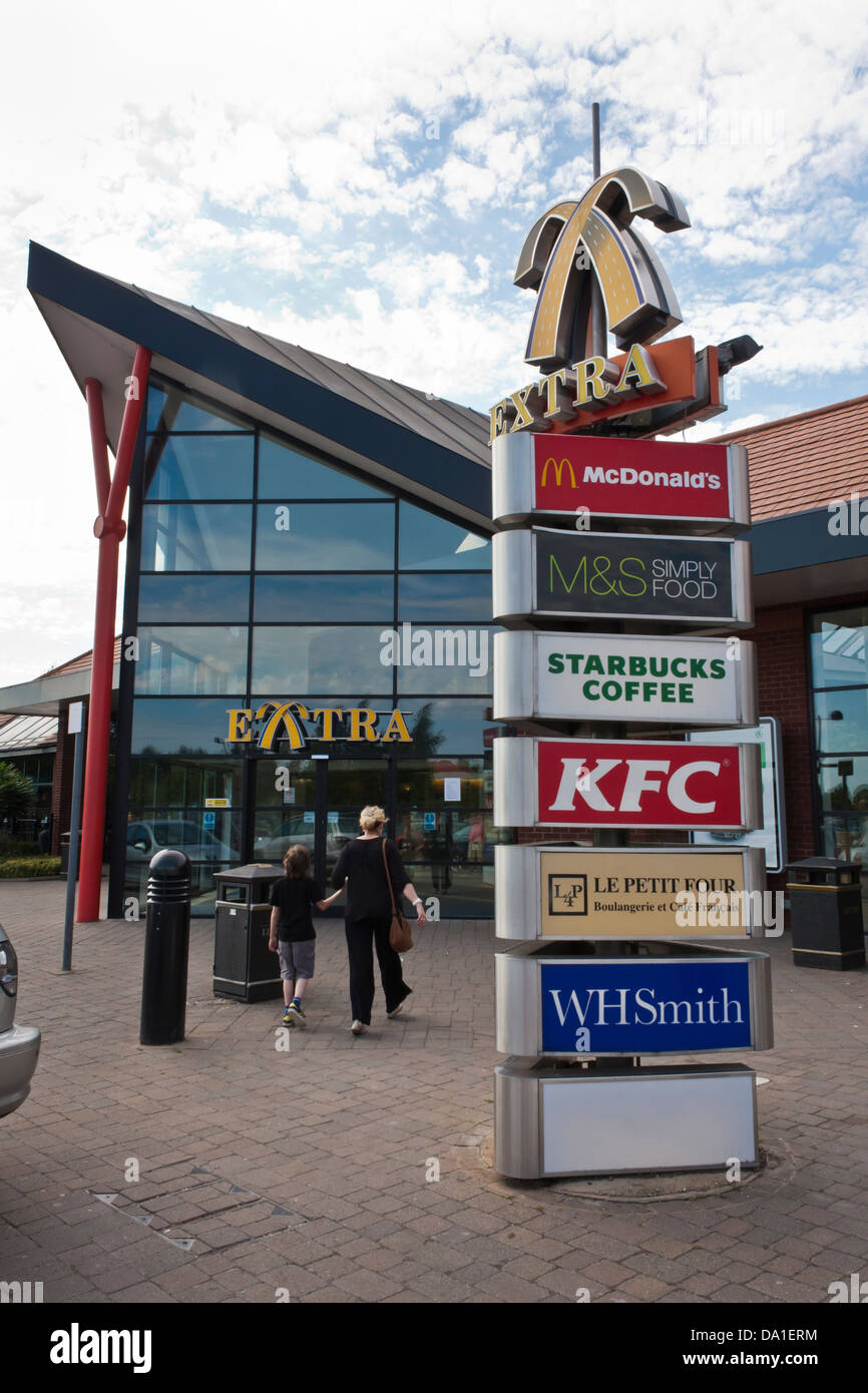 Entrance to a UK motorway service station with signs for food and leisure services. Stock Photo