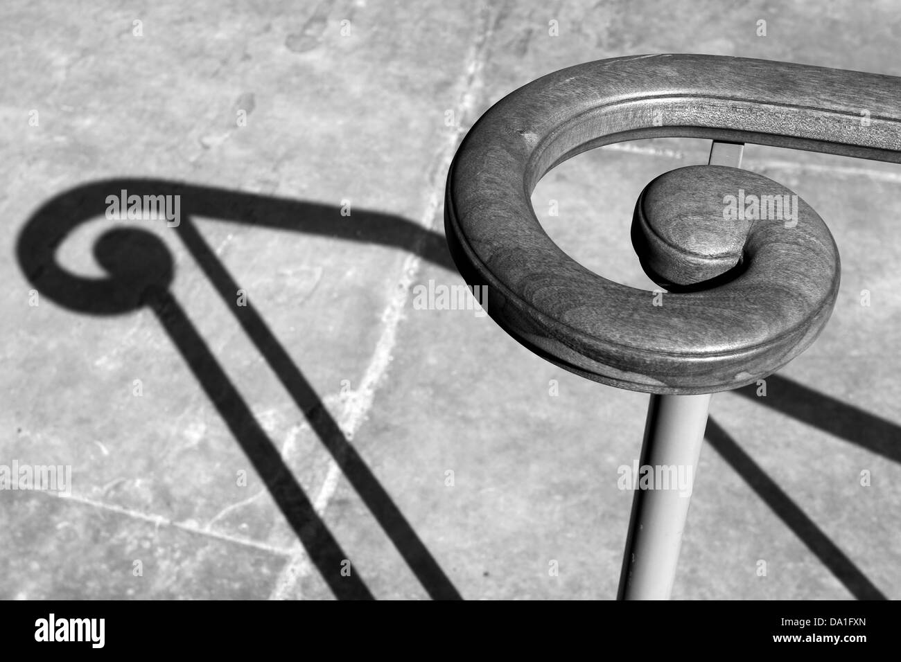 The spiral of a  handrail and it's shadow resembling a musical note. Stock Photo