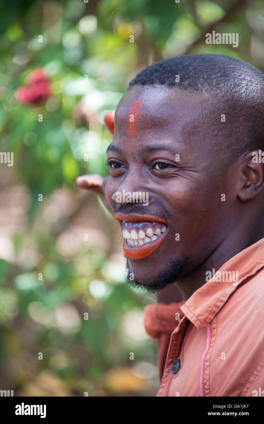 A guide demonstrates the use of the spice plant Annatto as 'Zanzibar lipstick'. Zanzibar, United Republic of Tanzania. Stock Photo