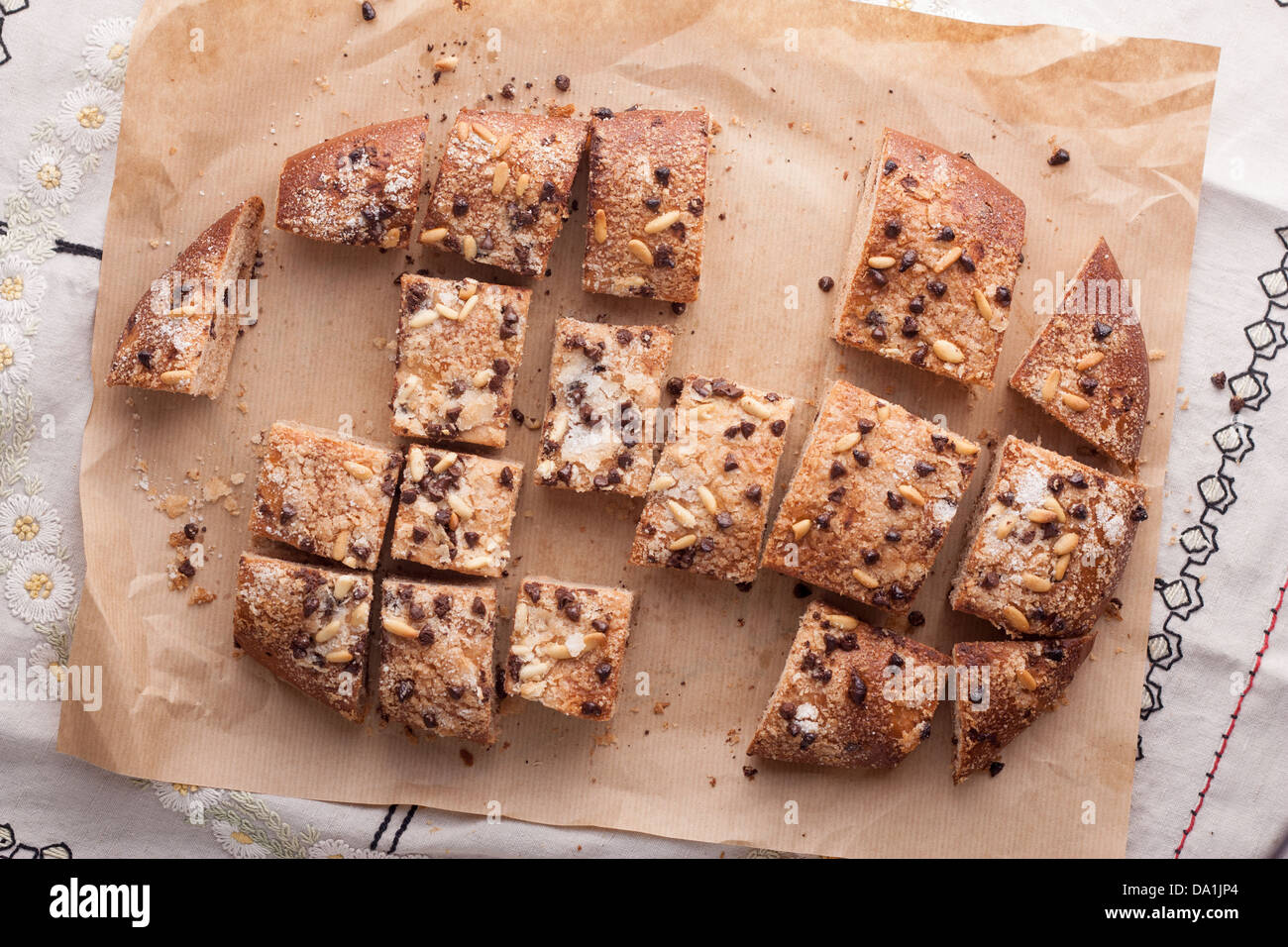 Traditional Catalan chocolate and pine nuts brioche cut in pieces Stock Photo