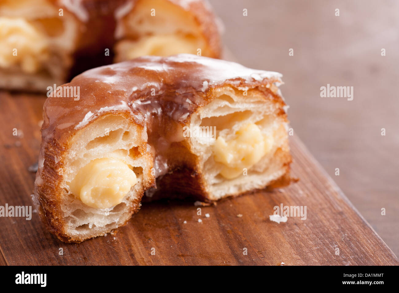 Cream croissant and doughnut mixture on a wooden table Stock Photo