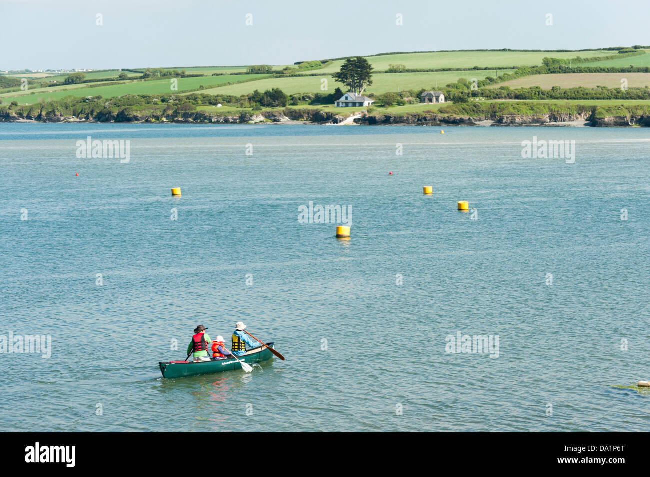 A family paddle a canadian canoe on River Camel estuary Padstow Cornwall UK on a sunny summer