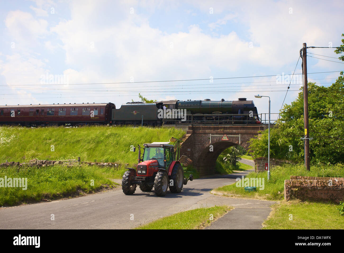 LMS Royal Scot Class 6115 Scots Guardsman steam train at Plumpton on the West Coast Main Line Railway with tractor. Stock Photo