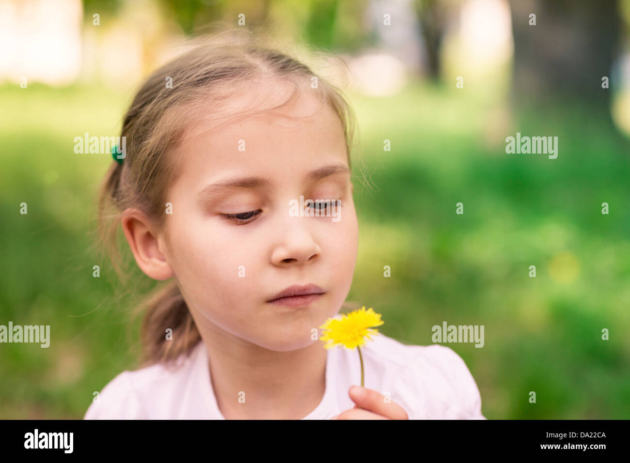 Beautiful little girl with dandelion flower outdoor Stock Photo - Alamy