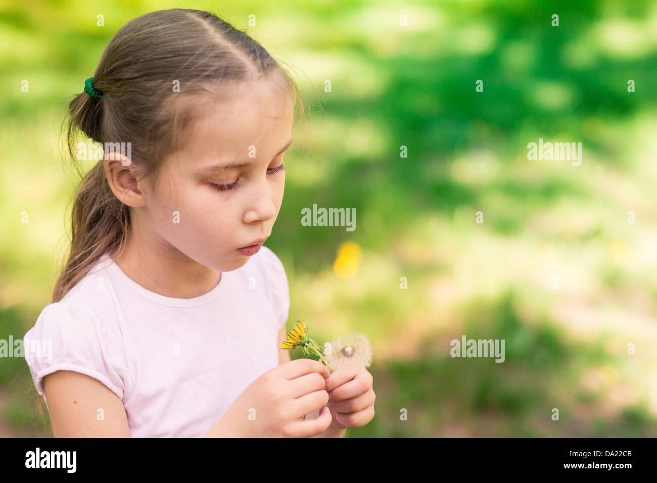 Beautiful little girl with dandelion flower outdoor Stock Photo - Alamy