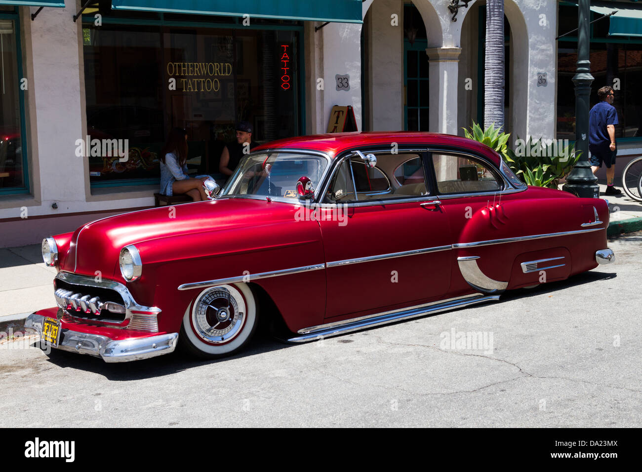 Customized 1953 Chevrolet parked on street in front of a tattoo parlor. Stock Photo