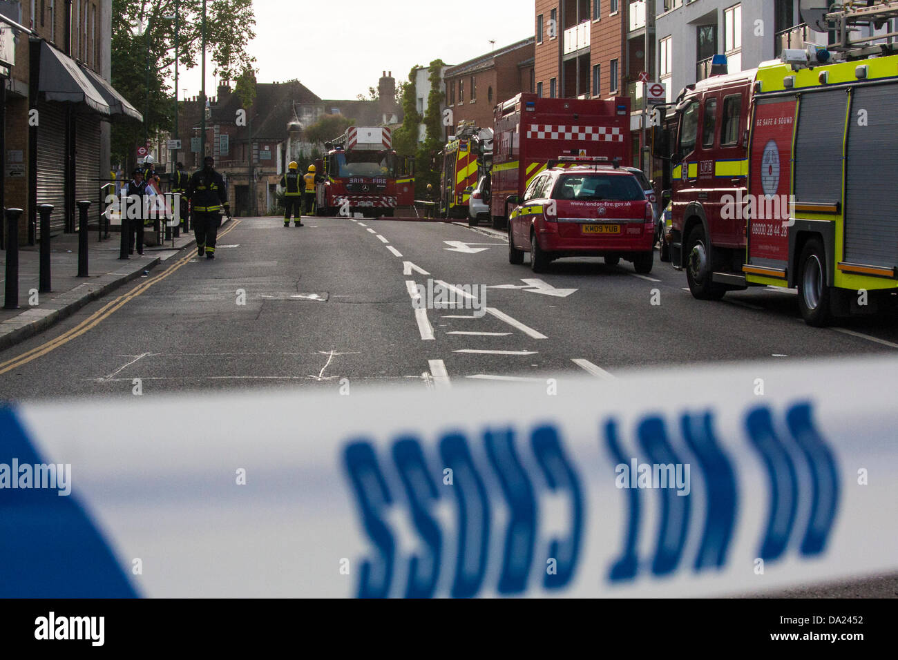 London, UK. 1st July, 2013. The usually busy Harrow Road was cordoned off causing traffic chaos as firefighters damped down a fire and cooled gas cylinders at The Wheel & Tyre Co, Kensal Green. Credit:  Paul Davey/Alamy Live News Stock Photo
