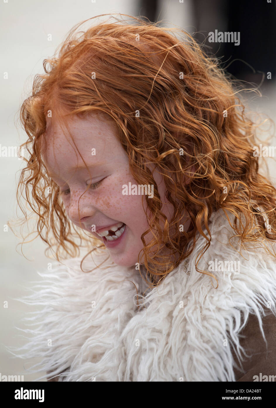 Young happy ginger haired girl playing with bubbles, Preston, UK Stock