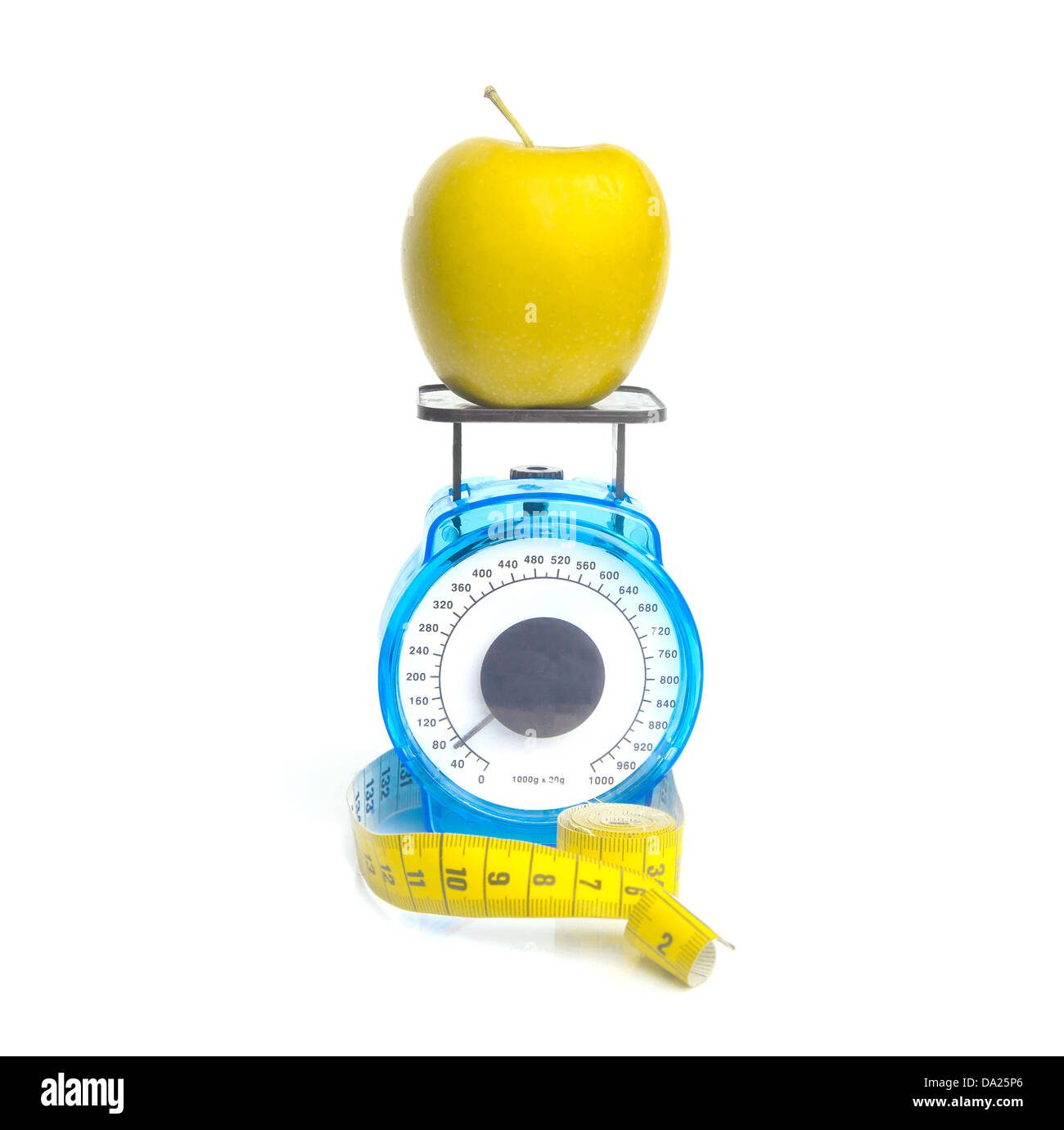 Weighing a yellow apple on kitchen scale: weight loss concept Stock Photo